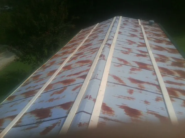 Rusted metal roof panels with new wood purlins before replacement — Storm Damage Roof Repair in Cherry Plain by Roofing Brothers
